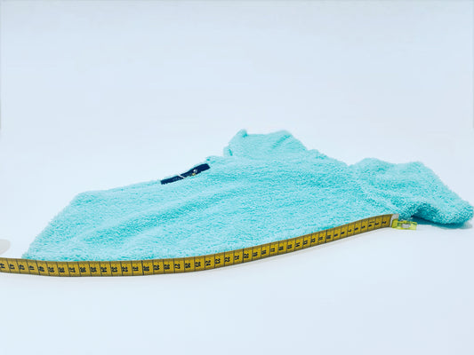 Sortie de bain menthe en éponge INnOVERTO Dog photographiée à plat avec un mètre ruban, première vue.